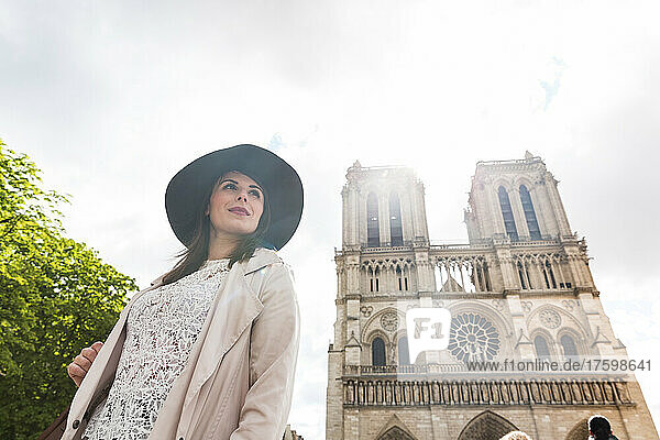 Junge Frau mit Hut in der Kathedrale Notre Dame im Urlaub