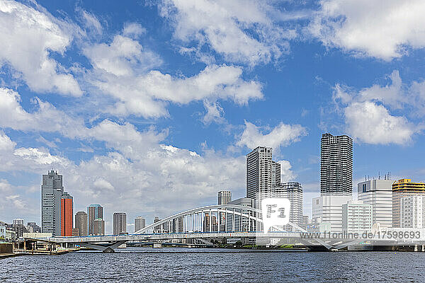 Japan  Kanto Region  Tokyo  Clouds over waterfront skyscrapers with Tsukiji Great Bridge in foreground