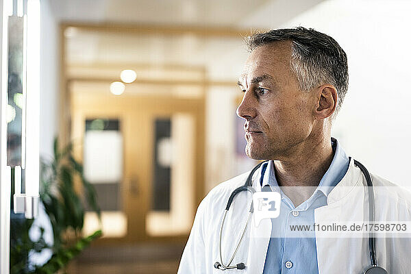 Confident doctor in lab coat at hospital