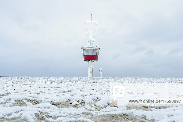 Germany  Schleswig-Holstein  Lubeck  Snow covered beach in Travemunde with lookout tower in background