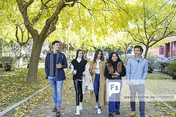 Junge Freunde gehen im College-Park spazieren