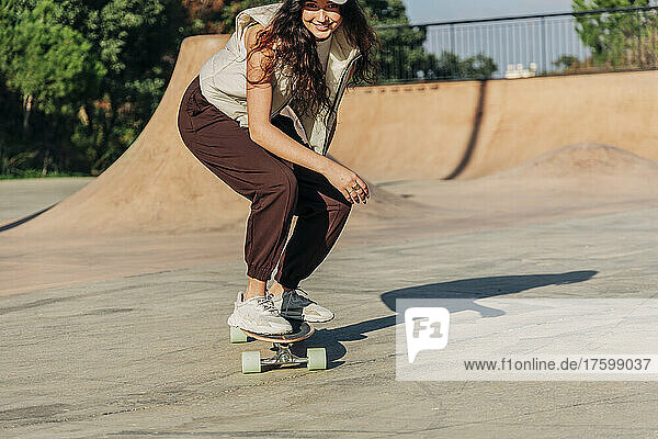 Woman skateboarding on sports ramp in park