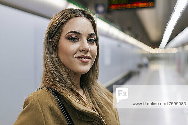 Smiling young woman at subway station