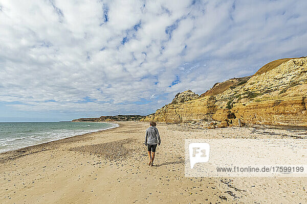 Australia  South Australia  Port Willunga  Female tourist walking alone along Port Willunga Beach