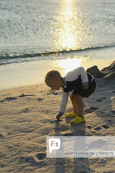Boy playing with sand on shore at beach  Crimea