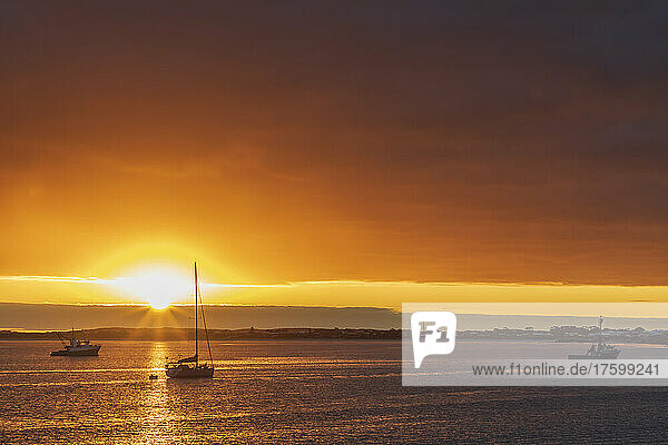 Australia  South Australia  Robe  Cloudy sky over boats floating near coast at moody sunset