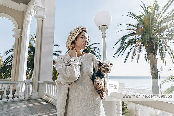 Blond woman with pet dog on sunny day