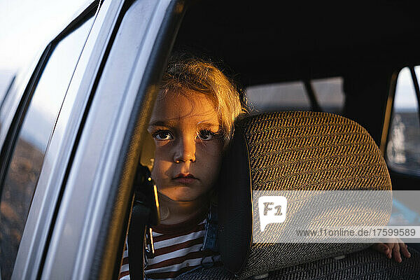 Thoughtful boy traveling in car on road trip