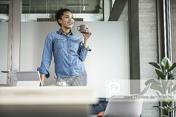 Young businesswoman having coffee at work place