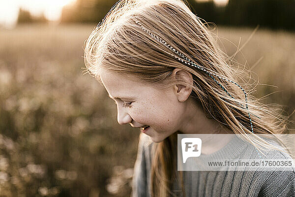 Girl with blond hair laughing at field