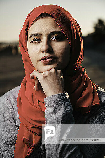 Young woman with hand on chin wearing hijab