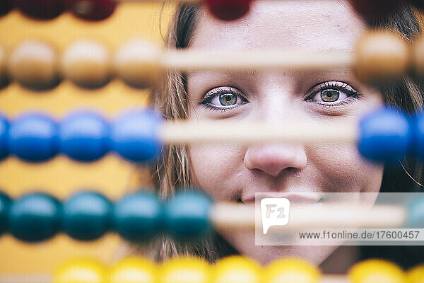 Young woman with gray eyes behind abacus
