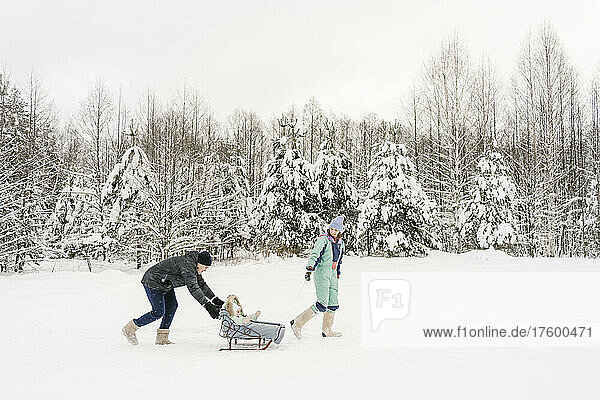 Playful parents with daughter in winter