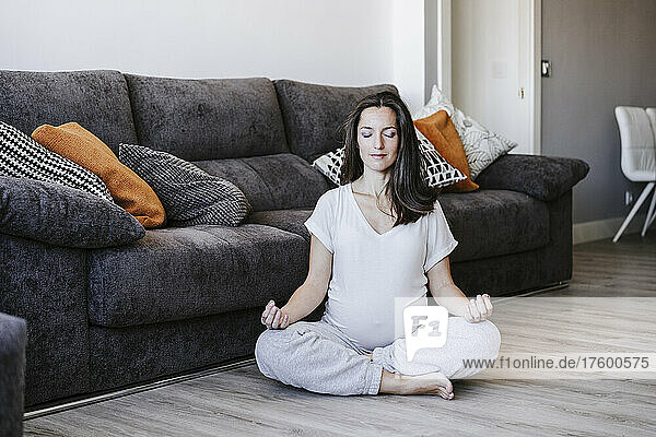 Pregnant woman meditating at home