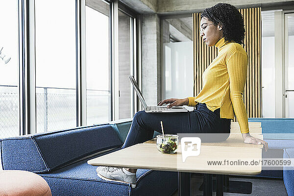 Young businesswoman working on laptop at desk in office