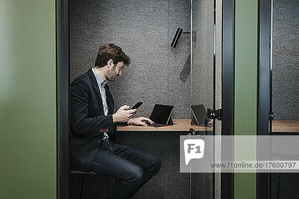 Businessman using tablet PC sitting at desk in cabin