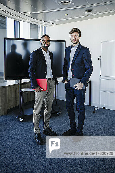 Business colleagues standing with tablet PC in office