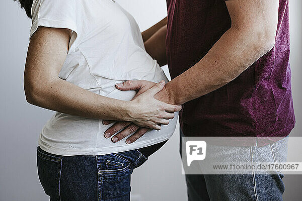 Man touching belly of pregnant woman at home