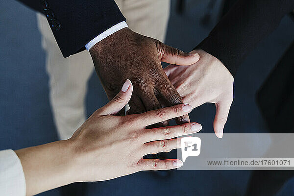 Multi-ethnic business colleagues stacking hands