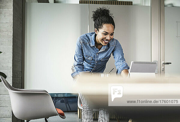 Smiling businesswoman working on tablet PC in office