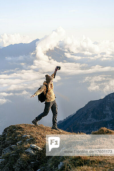 Woman with arms outstretched walking at edge of mountain at Caucasus Nature Reserve in Sochi  Russia