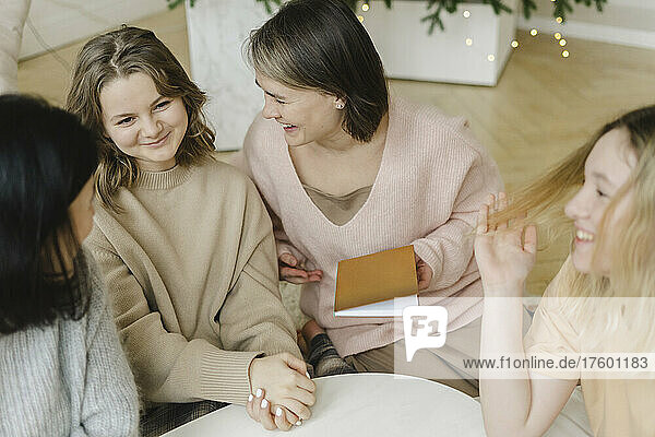 Cheerful women talking with their daughters at home