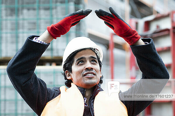 Engineer with arms raised gesturing outdoors