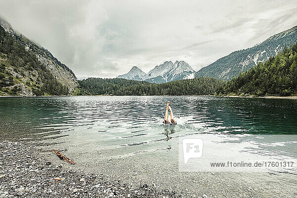 Man swiming in Blindsee lake by Mieming Range  Tirol  Austria