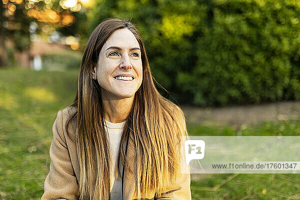 Smiling woman with brown hair at park