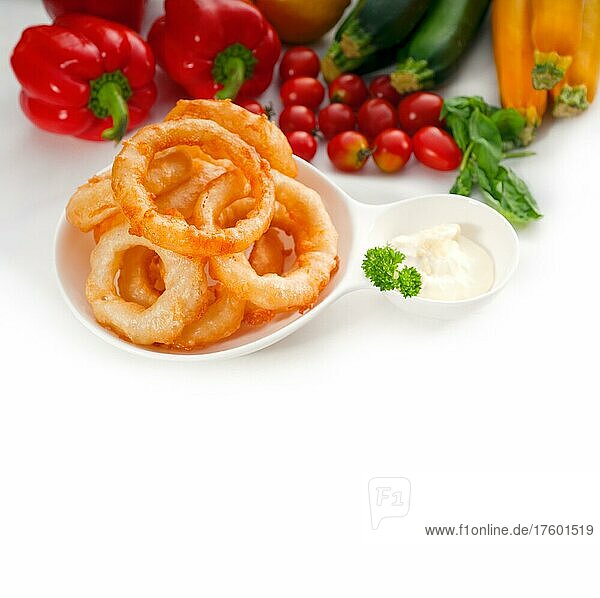 Goldene  frittierte Zwiebelringe  serviert mit Mayonnaise-Dip und frischem Gemüse oln Hintergrund