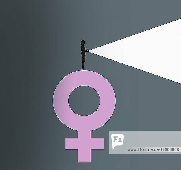 Frau leuchtet mit Taschenlampe von der Spitze eines weiblichen Geschlechtssymbols
