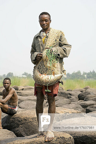 Ein kongolesischer Fischer bereitet sich darauf vor  sein Netz vom Ufer aus auszuwerfen; Kongo-Fluss  Kinshasa  Demokratische Republik Kongo.