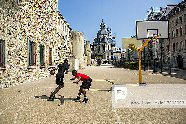 Junge Männer spielen Basketball im Innenhof hinter der Kirche Saint-Paul Saint-Louis in Le Marais  Paris  Frankreich; Paris  Frankreich