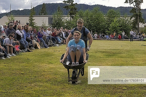 A brother and sister compete in a logging show wheelbarrow race. A throwback to the heyday of the logging industry  the competitions bring communities together for fun and games on Prince of Wales Island; Prince of Wales Island  Alaska  United States of America