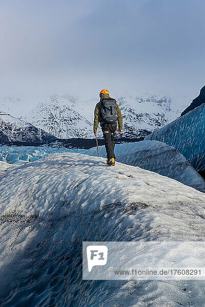 Ein Mann läuft zwischen einer der vielen Gletscherspalten des Vatnajokull-Gletschers.