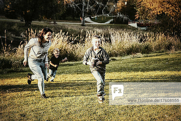 Mutter  die ihren Sohn an einem schönen Herbsttag in einem Stadtpark mit einem Fußballspiel verfolgt; St. Alberta  Alberta  Kanada