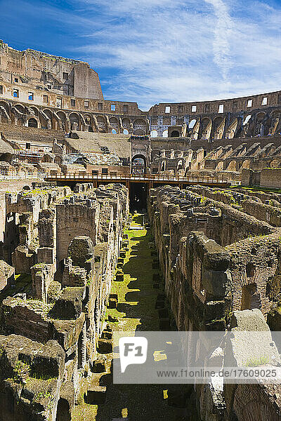 Blick durch die unterirdischen Tunnel und den unterirdischen Boden im Inneren des berühmten Kolosseums mit blauem Himmel und Touristengruppen beim Sightseeing; Rom  Latium  Italien