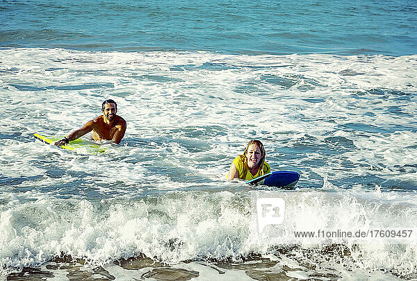 Glückliches Ehepaar spielt in den Wellen mit Bodyboards am D. T. Fleming Beach; Kapalua  Maui  Hawaii  Vereinigte Staaten von Amerika