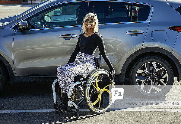 Junge querschnittsgelähmte Frau in ihrem Rollstuhl vor ihrem umgebauten Fahrzeug auf einem Parkplatz; Edmonton  Alberta  Kanada