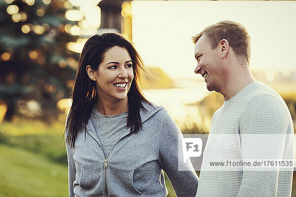 Ein erwachsenes Paar  das im Herbst in einem Park spazieren geht und miteinander spricht; St. Albert  Alberta  Kanada