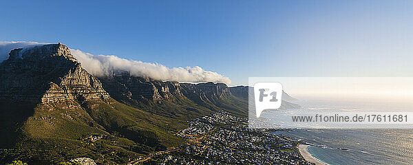 Cloud formation creating table cloth effect over the Twelve Apostles mountain range with an overview of Cape Town city skyline and view of Camps Bay along the Atlantic Ocean Coast; Cape Town  Western Cape Province  South Africa