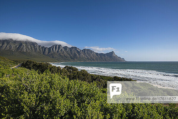 Blick auf den Strand von Kogel Bay entlang der malerischen R44-Route mit den Kogelbergen in der Ferne; Kogel Bay  Kapstadt  Westkap  Südafrika