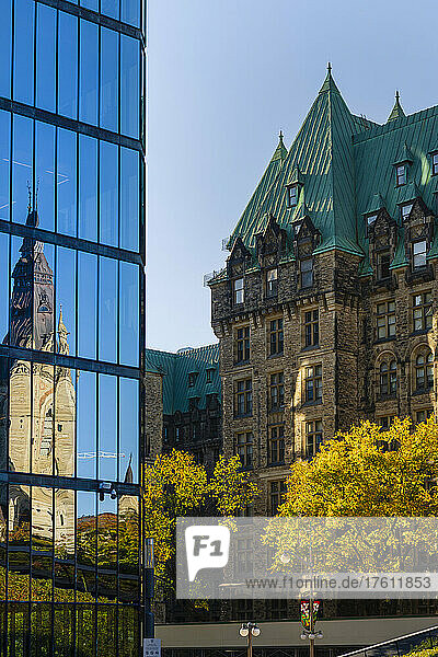 Der Westblock des kanadischen Parlamentsgebäudes und das kanadische Parlamentsgebäude spiegeln sich in der Glasfassade eines Gebäudes in der nationalen Hauptstadt Ottawa; Ottawa  Ontario  Kanada