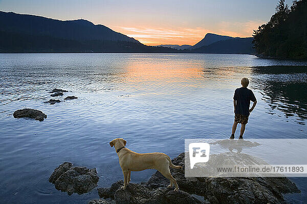 Teenager and Dog looking at Sunset  Fulford Harbour  Salt Spring Island  British Columbia  Canada
