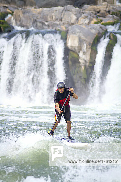A stand up paddle boarder in white water just below Great Falls.; Great Falls  Potomac River  Maryland/Virginia.