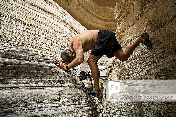 Photographer rock climbing with tripod  Grand Canyon  Arizona.