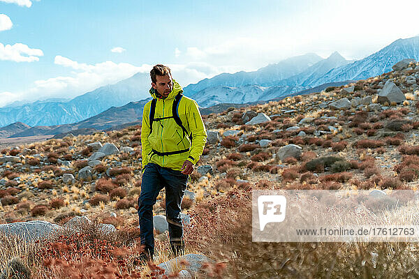 Man in a bright yellow jacket hiking in the Eastern Sierra; California  United States of America