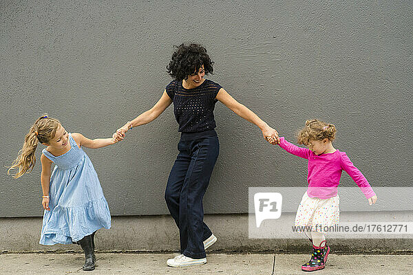 Mother playful with young daughters; Toronto  Ontario  Canada