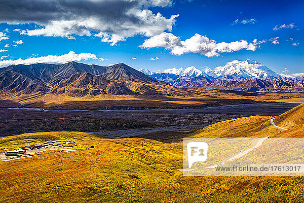 View of Mount Denali (McKinley)  Mount Eielson and Eielson Visitor Center with the fall colored tundra hills in the foreground in autumn; Denali National Park and Preserve  Interior Alaska  Alaska  United States of America