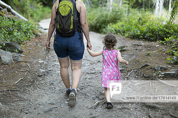 Mutter und kleine Tochter halten sich an den Händen und gehen gemeinsam einen Wanderweg im Smuggler Cove Marine Provincial Park an der Sunshine Coast von BC  Kanada; British Columbia  Kanada